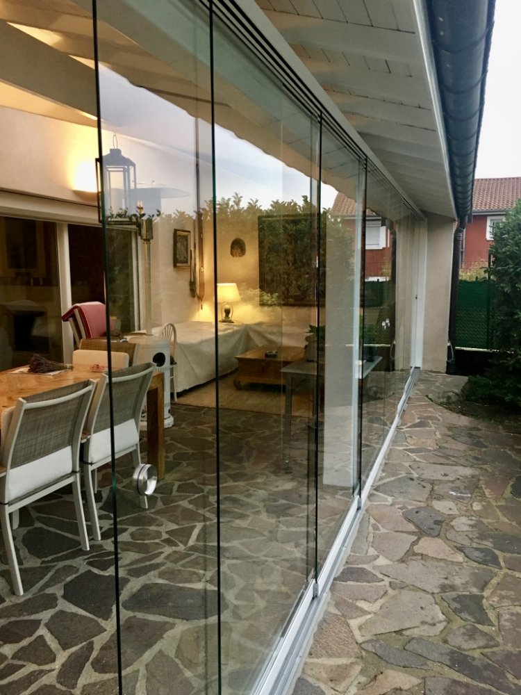 APRES Réalisation d'une fermeture de terrasse avec des coulissants entièrement vitrés à Limas
