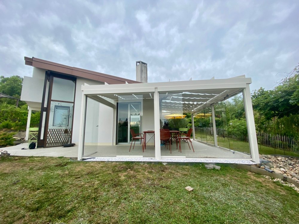 Installation d’une toiture vitrée sur-mesure et de coulissants pivotants : élégance et transparence pour une charmante maison dans l’Ain (01)