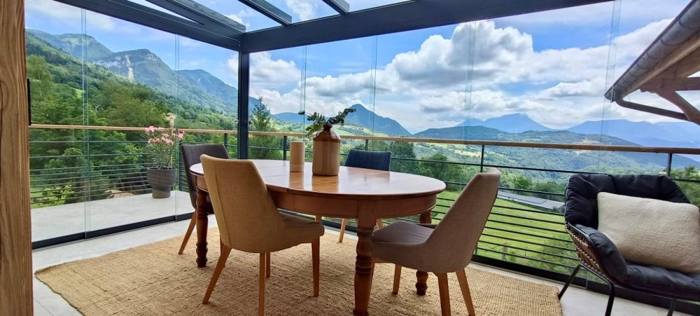 Mise en place d'une pergola vitrée munie de coulissants pour admirer une vue imprenable sur la région Haute-Savoie.