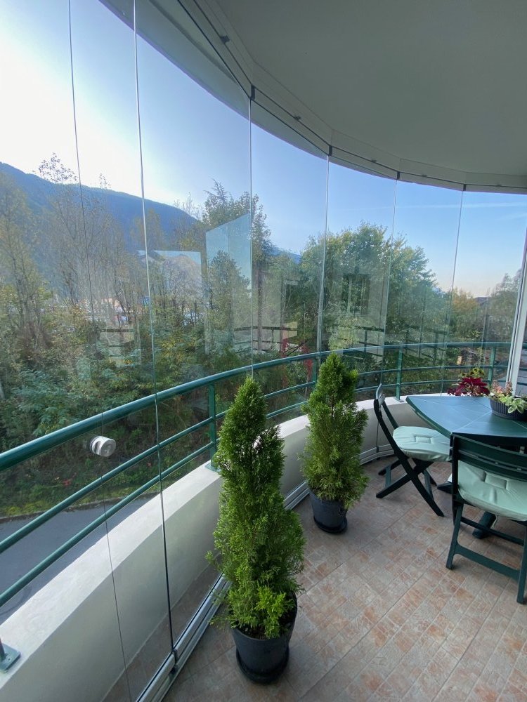 Fermeture d'une terrasse en coulissants pivotants courbes à facettes près de Lyon