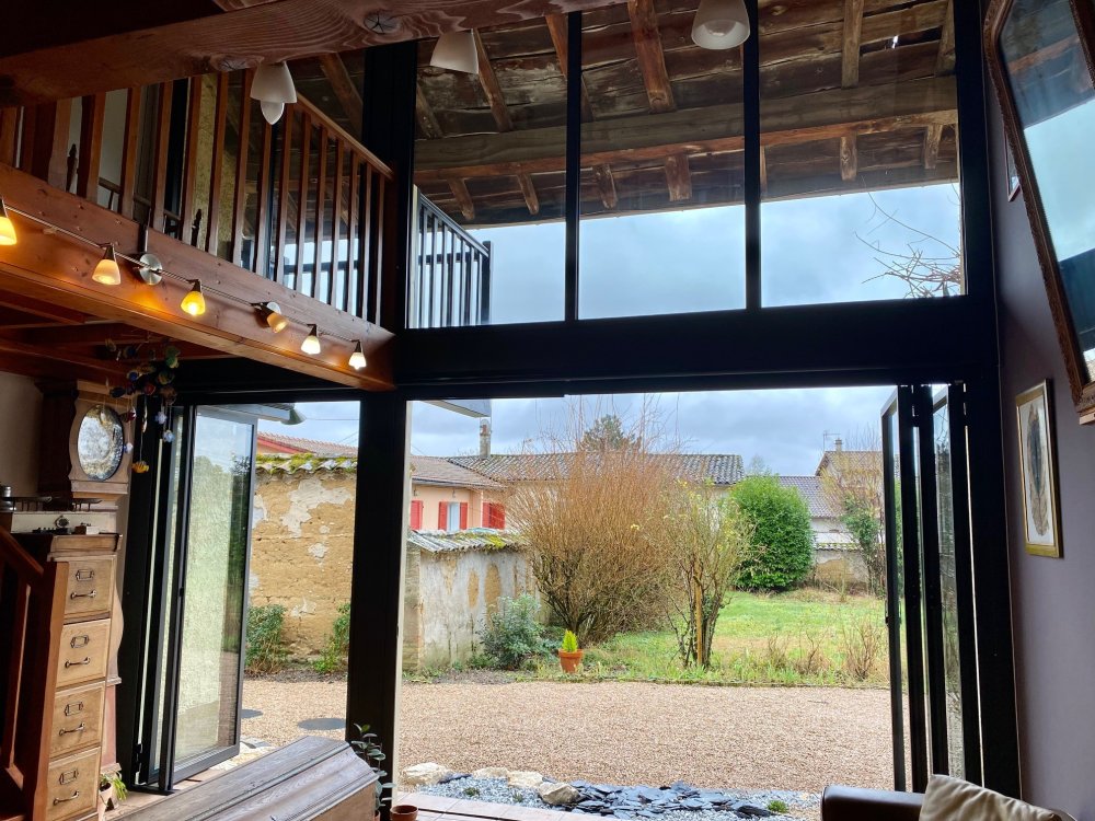 Installation sur-mesure de baies accordéon et d'un châssis fixe dans une charmante maison située dans l'Ain