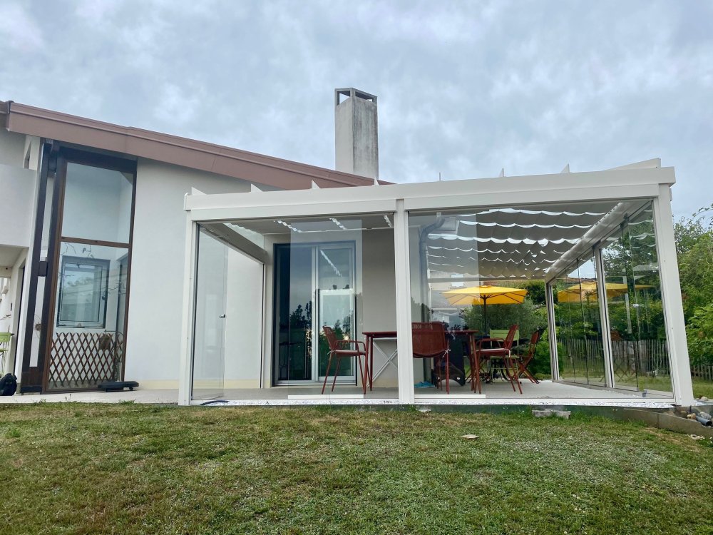 Installation d’une toiture vitrée sur-mesure et de coulissants pivotants : élégance et transparence pour une charmante maison dans l’Ain (01)
