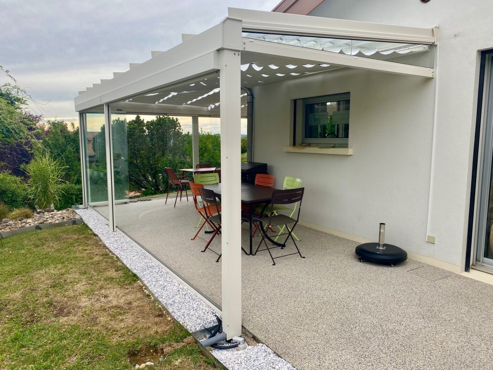 Installation d’une toiture vitrée sur-mesure et de coulissants pivotants : élégance et transparence pour une charmante maison dans l’Ain (01)
