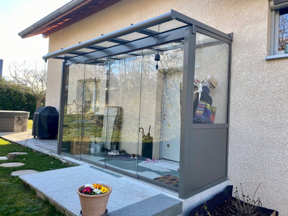 Mise en place d'une toiture vitrée pour créer un SAS d'entrée entièrement vitrée dans une charmante villa en région Rhône-Alpes.