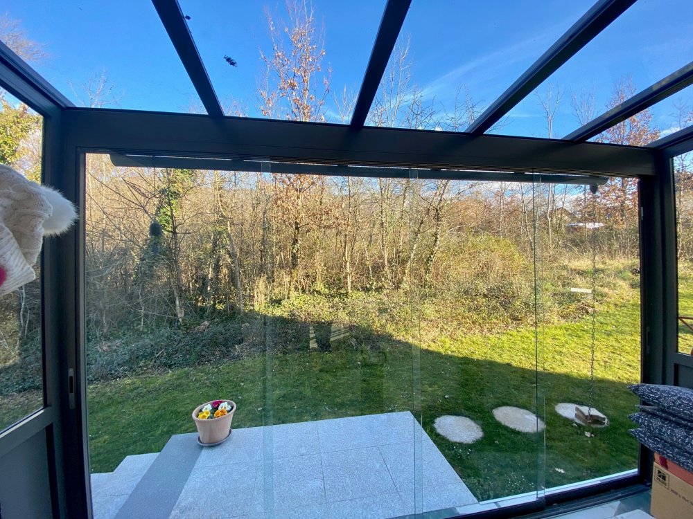 Mise en place de coulissant pour créer un SAS d'entrée entièrement vitrée dans une charmante villa en région Rhône-Alpes.