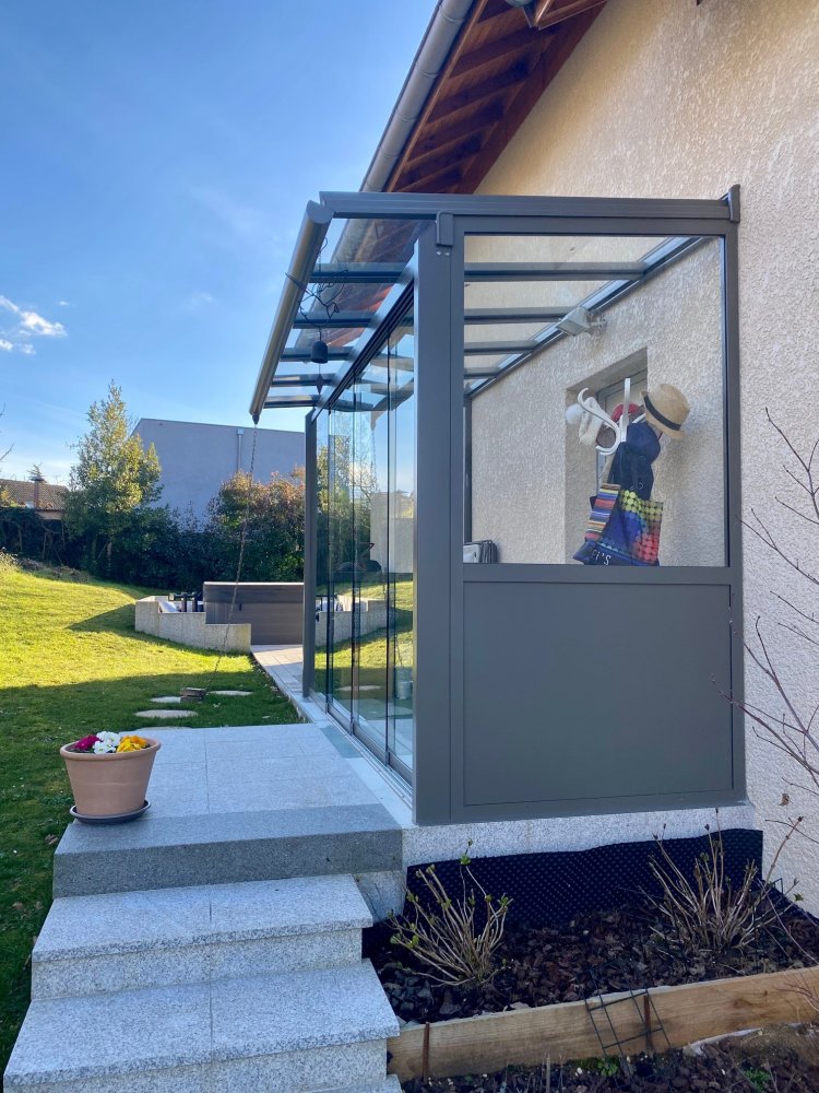 Mise en place d'une toiture vitrée pour créer un SAS d'entrée entièrement vitrée dans une charmante villa en région Rhône-Alpes.
