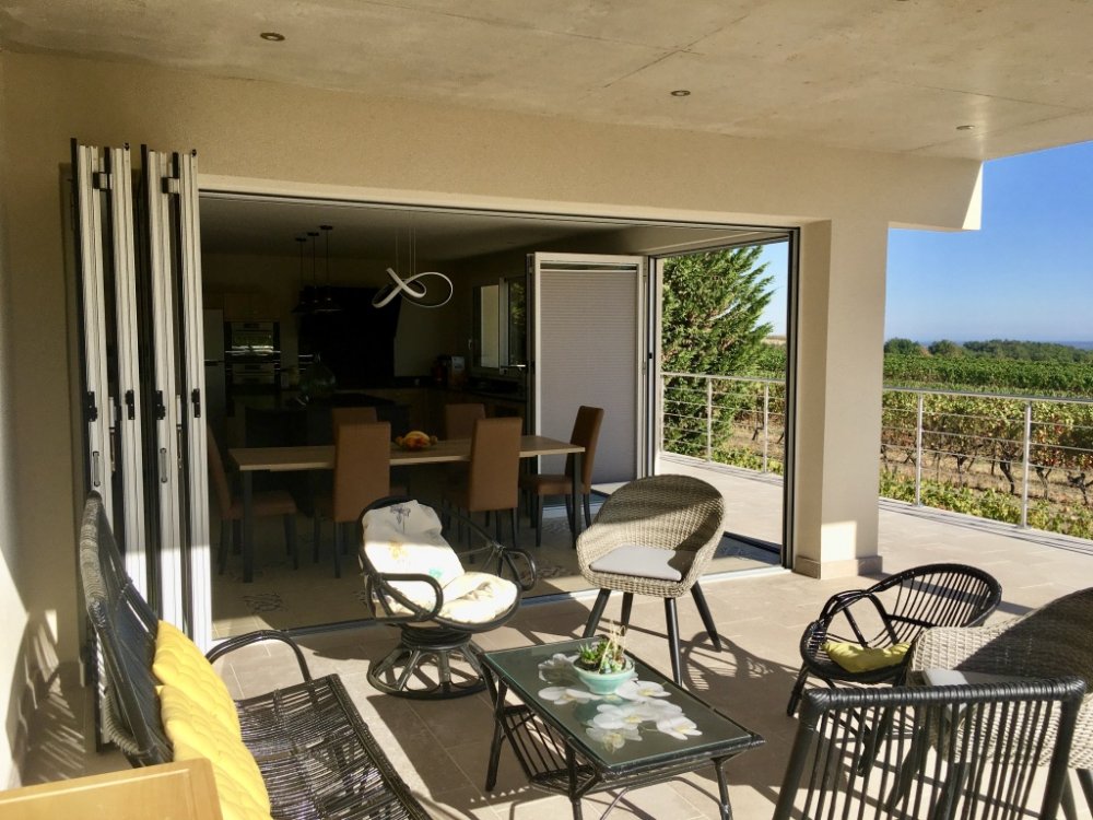 Réalisation de baies accordéon vitrées et thermique pour fermeture d'extension pour une cuisine donnant sur la terrasse.