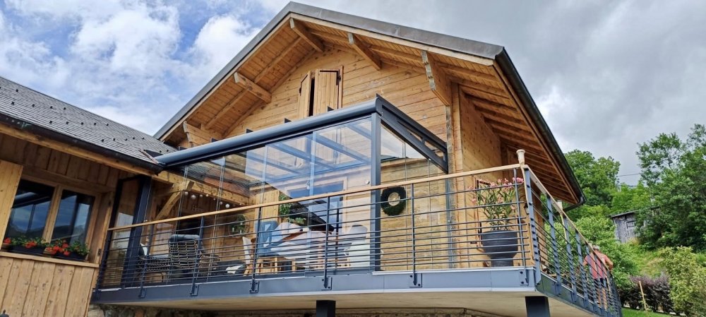 Installation d'une pergola entièrement vitrée équipée de coulissants pour profiter d'une vue sur la région Haute-Savoie.
