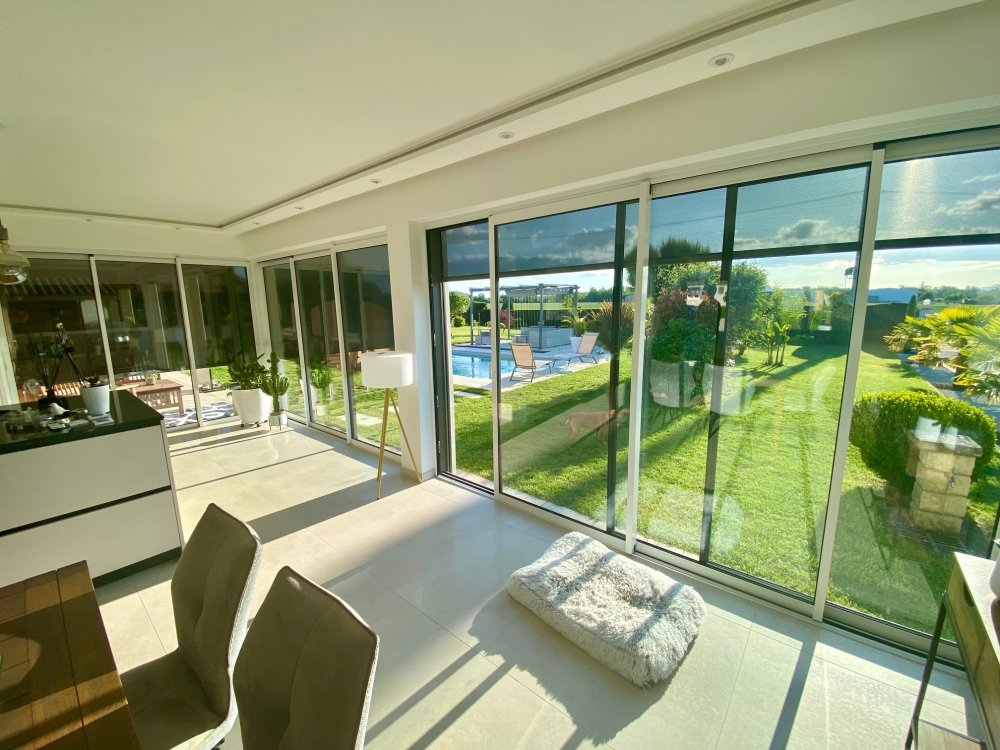 Réalisation d'une extension de terrasse comprenant des coulissants en bicoloration dans une villa chaleureuse implantée dans l'Ain (01)
