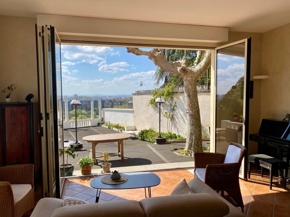 Remplacement d’une baie accordéon en bois par un modèle en aluminium dans une villa surplombant Lyon. 