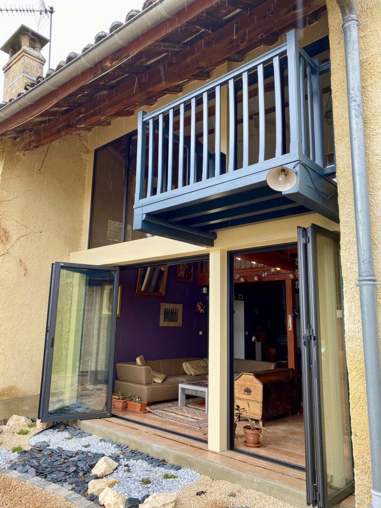 Fourniture et pose de baies accordéon et d'un châssis fixe dans une charmante maison située dans l'Ain