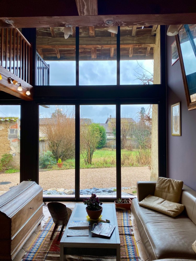 Installation de baies accordéon et d'un châssis fixe dans une charmante maison située dans l'Ain
